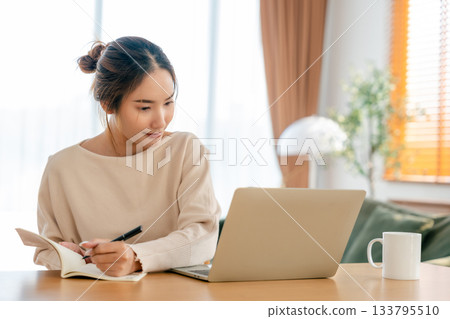 Young Asian woman happy positive cute beautiful business woman sit indoors in living room 133795510