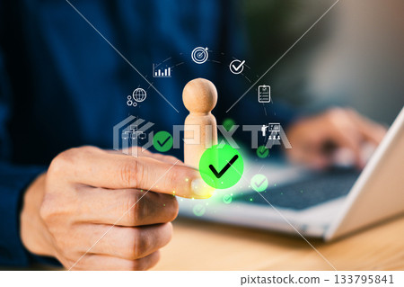 Hand holding wooden figure with digital icons and check marks, symbolizing talent approval, HR evaluation, employee selection, business management, and strategic decision-making in modern Hand holding wooden figure with digital icons and check marks, symbolizing talent approval, HR evaluation, employee selection, business management, and strategic decision-making in modern 133795841
