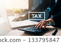 Businessman using calculator and laptop with tax icon overlay, representing tax calculation, financial planning, online accounting, and corporate finance in modern digital environment. 133795847