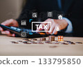 Close up of hands using calculator with stacked coins and tax icon, representing financial strategy, income planning, tax saving, personal finance, money management, and accounting. 133795850