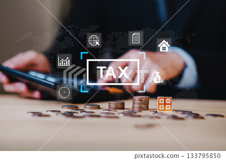 Close up of hands using calculator with stacked coins and tax icon, representing financial strategy, income planning, tax saving, personal finance, money management, and accounting. 133795850