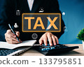Tax concept with businessman using calculator and writing notes, showing tax planning, income deduction, and financial strategy in business and personal tax management. 133795851