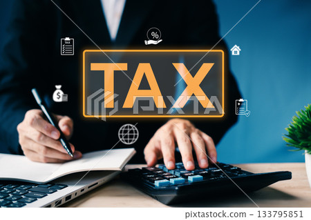 Tax concept with businessman using calculator and writing notes, showing tax planning, income deduction, and financial strategy in business and personal tax management. 133795851