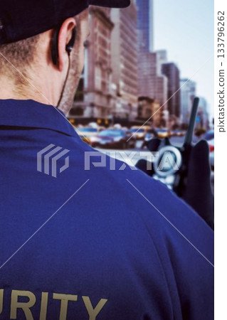 Cropped image of security holding walkie talkie 133796262