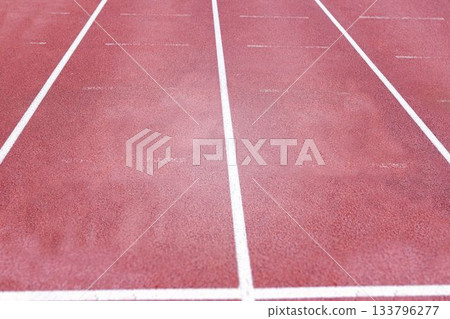 Flat design red running track is featuring three lanes with crisp white lines and textured surface 133796277