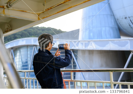 一位老婦人在前往隱岐群島的渡輪甲板上用手機拍攝風景。 133796841