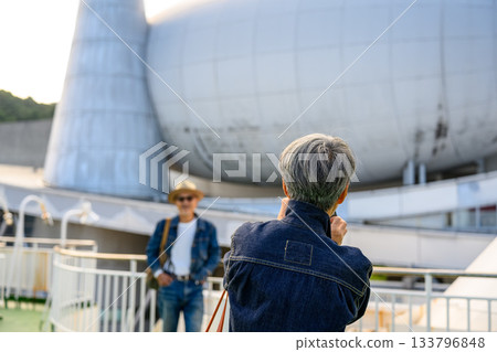 Departing from Nanarui Port, bound for Oki Island. A senior couple taking a commemorative photo on the ferry deck. Departing from Nanarui Port, bound for Oki Island. A senior couple taking a commemorative photo on the ferry deck. 133796848