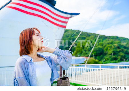 一位年輕的女旅行者從船上眺望大海和島嶼。 133796849