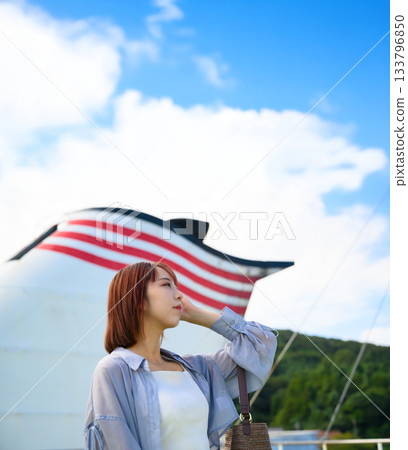 一位年輕女子站在渡輪煙囪前，預示著即將離去。 133796850
