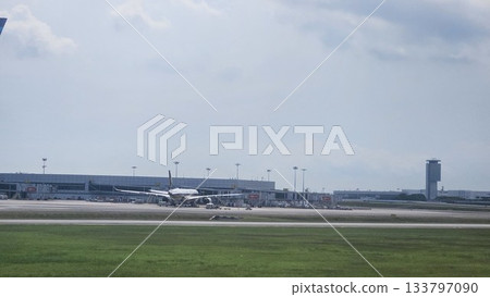 Changi Airport lush greenery spells its name beside a busy runway 133797090