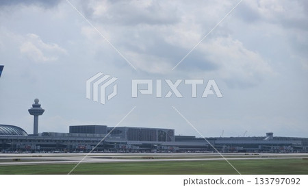 Changi Airport lush greenery spells its name beside a busy runway 133797092
