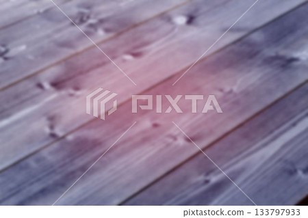 Flat design surface is displaying diagonal wooden planks with visible grain knots under pink glow 133797933