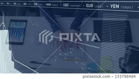 Typing woman's hands navigating financial chart overlays on white desk, with tablet and headphones 133798484