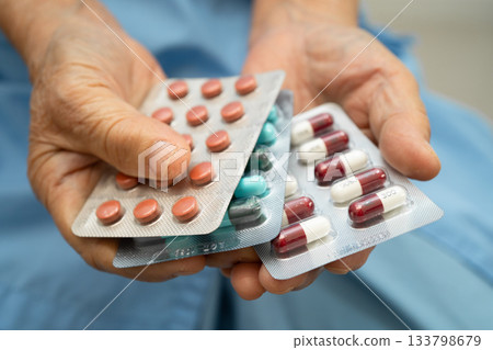 Asian elderly woman holding pill drug in hand, strong healthy medical. 133798679