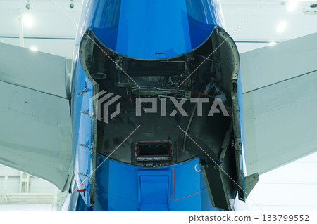 Detailed view of an aircraft tail section showing maintenance access during scheduled inspection at the airport hangar in early morning Detailed view of an aircraft tail section showing maintenance access during scheduled inspection at the airport hangar in early morning 133799552