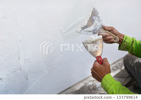 Painter's hand puttied wall using A paint trowel. 133799614