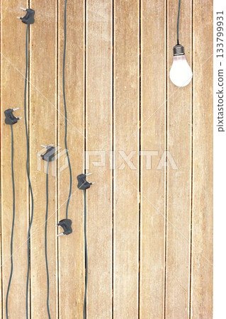 Bulb and plugs on wooden background 133799931