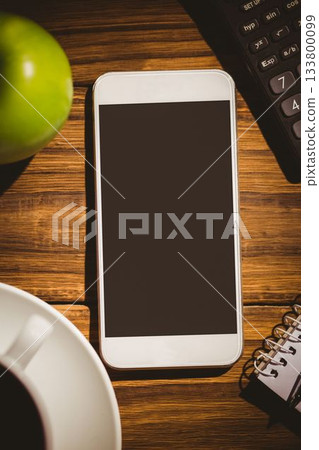 White smartphone is lying on tabletop in flat design, showing blank black screen, cup and notebook White smartphone is lying on tabletop in flat design, showing blank black screen, cup and notebook 133800099