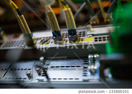 Flat design is showing LC fiber optic cables connecting into network patch panel chassis in rack 133800101