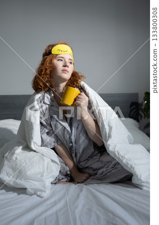 calm woman leisurely unwinds during sunrise with hot beverage and bright sunlight 133800308