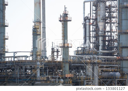Refinery network showing flat design distillation columns, pipes, catwalks, valves under pale sky Refinery network showing flat design distillation columns, pipes, catwalks, valves under pale sky 133801127