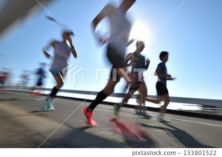 Marathon: Marathon runners running up a hill with slow shutter 133801522