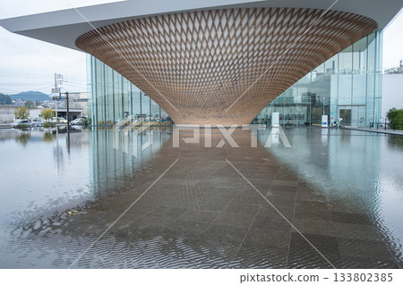 Mt. Fuji World Heritage Centre at Fujinomiya, Shizuoka, Japan - Nov 18, 2024 : Modern architectural wooden canopy over reflective water pool at building entrance 133802385