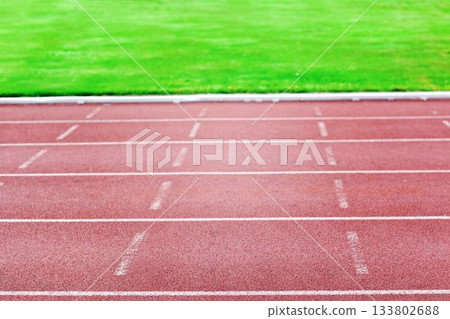 Flat design is showing red outdoor rubber track lanes with white markings leading into grass field Flat design is showing red outdoor rubber track lanes with white markings leading into grass field 133802688