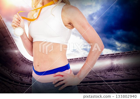 Midsection of female athlete holding medal Midsection of female athlete holding medal 133802940