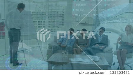 Presenter in business attire writing on flipchart pad in boardroom, with notepads, pens, copy space 133803421