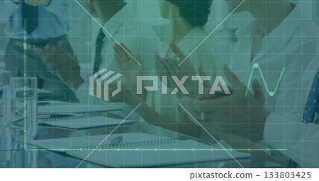 Clapping team in business attire at conference table with notebooks pens glasses and data overlay 133803425
