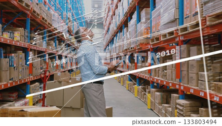 In warehouse, worker using tablet with image overlay on shelves 133803494