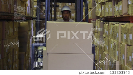 Operator wearing safety helmet lifting boxes with forklift in storage aisle, with metal racks Operator wearing safety helmet lifting boxes with forklift in storage aisle, with metal racks 133803543