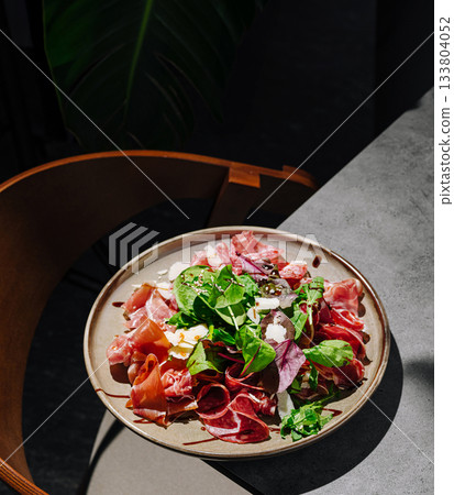 Colorful salad with various meats and greens served on a plate 133804052