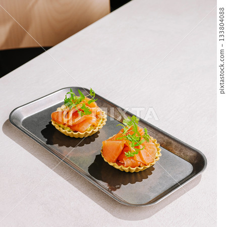 Delicious seafood tartlets served on a sleek metallic tray in a modern setting 133804088