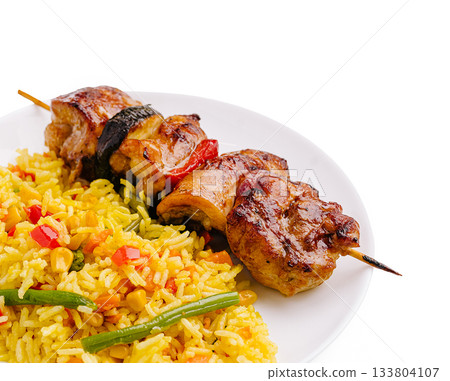 Delicious chicken skewers served with vibrant vegetable rice blend Delicious chicken skewers served with vibrant vegetable rice blend 133804107