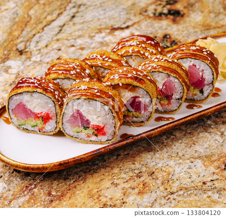 Delicious sushi rolls served on a plate with ginger and sauce 133804120