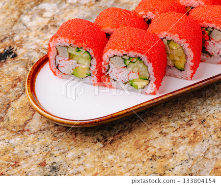Colorful sushi rolls on a decorative plate with a granite background 133804154