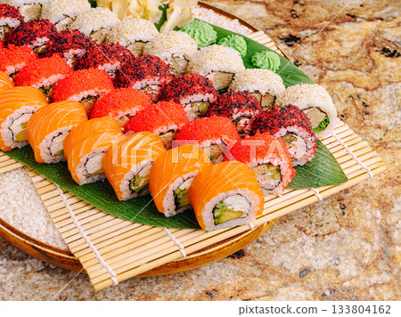 Colorful sushi platter served on bamboo mat in elegant setting Colorful sushi platter served on bamboo mat in elegant setting 133804162