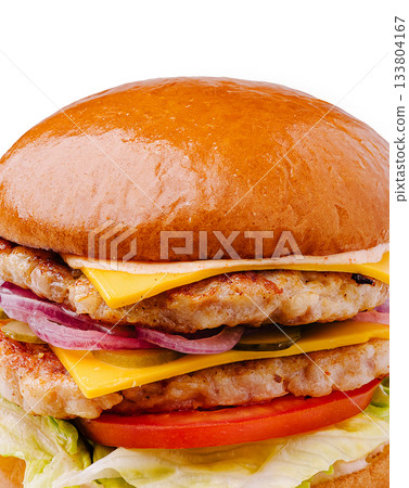 Juicy chicken burger stacked with cheese and fresh toppings in close-up 133804167