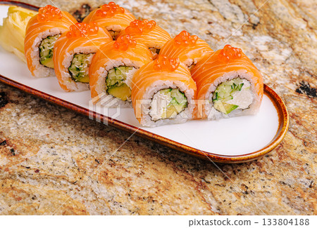 Delicious sushi rolls with salmon and avocado on a stylish plate Delicious sushi rolls with salmon and avocado on a stylish plate 133804188