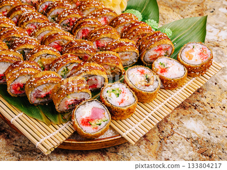 Delicious sushi rolls arranged on a platter with garnish and colorful fillings Delicious sushi rolls arranged on a platter with garnish and colorful fillings 133804217
