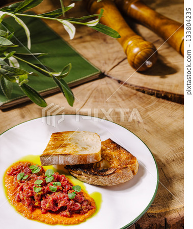 Freshly prepared dish with bread and sauce on rustic wooden table Freshly prepared dish with bread and sauce on rustic wooden table 133804235
