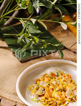 Delicious pasta dish with seafood served on a rustic wooden table Delicious pasta dish with seafood served on a rustic wooden table 133804241