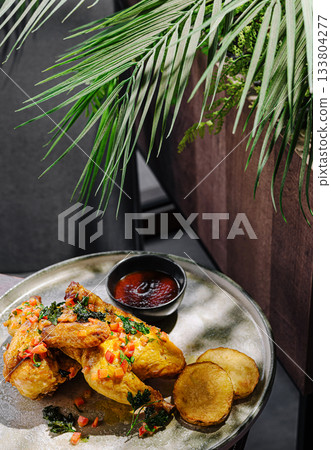 Delicious fried chicken served with dipping sauce and sides Delicious fried chicken served with dipping sauce and sides 133804277
