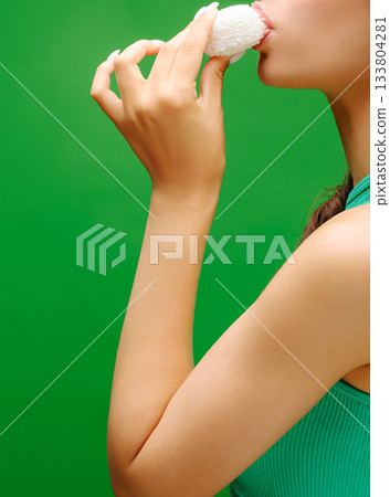 Enjoying a sweet treat against a vibrant green backdrop for a fun day Enjoying a sweet treat against a vibrant green backdrop for a fun day 133804281