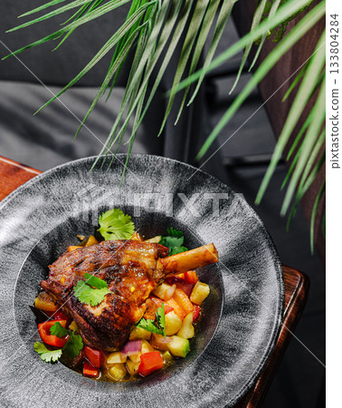 Delicious lamb dish with fresh vegetables served on a stylish plate 133804284