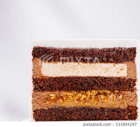 Delicious layered chocolate cake with creamy filling and nuts 133804297