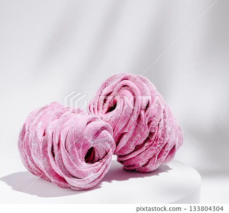 Colorful pink meringues arranged artistically on a light background Colorful pink meringues arranged artistically on a light background 133804304