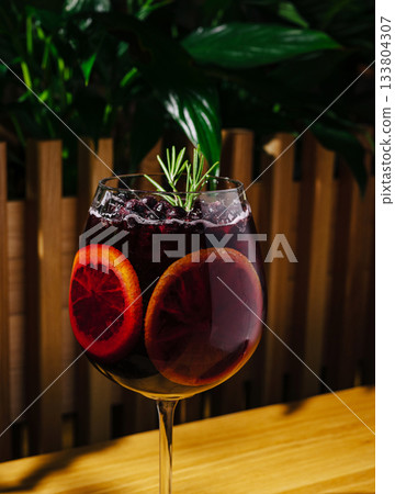 Refreshing drink with blood orange and rosemary served indoors 133804307